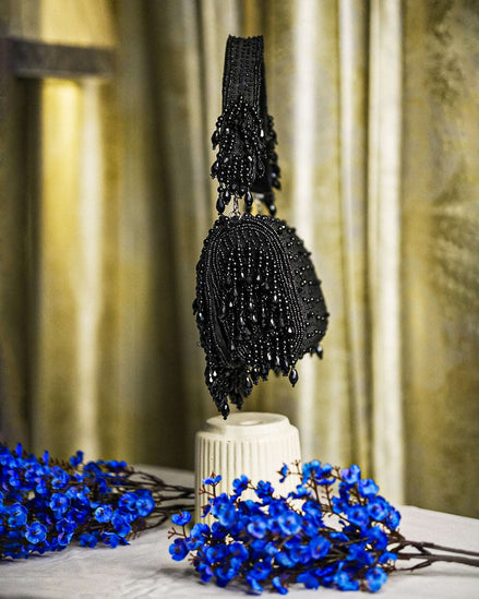 Black beaded hobo bag with vertical sequin texture and dangling fringe