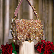 Pink crystal hobo bag with top handles and dangling bead fringe