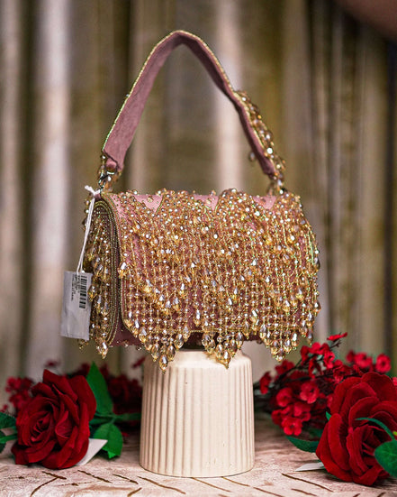 Pink crystal hobo bag with top handles and dangling bead fringe