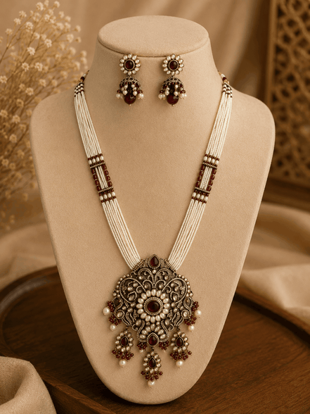 Gold-tone heritage necklace with large filigree pendant and matching stud-to-drop earrings.