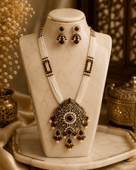 Layered beaded necklace with large ornate pendant and dangling gemstone drop earrings.