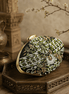 Black fabric clutch with green bead embroidery and gold clasp, side angle
