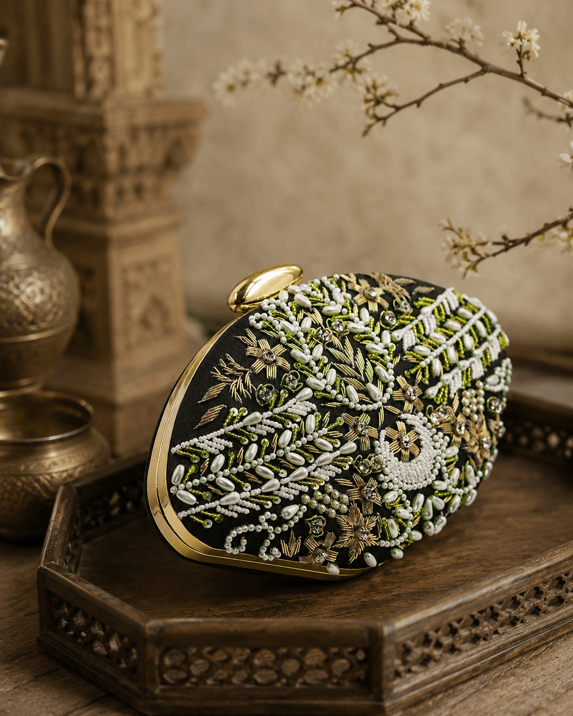 Black fabric clutch with green bead embroidery and gold clasp, side angle