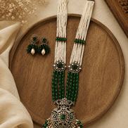 Emerald green beaded pearl necklace set with ornate pendant and stud earrings