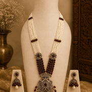 Maroon beaded pearl necklace set with ornate pendant and matching stud earrings