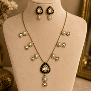 Black teardrop pendant necklace with small gold bow accents and matching drop earrings