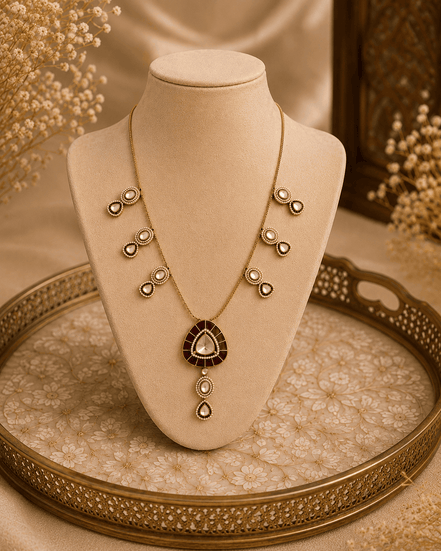 Gold teardrop pendant necklace set with small bow motifs and matching drop charm