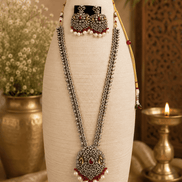 Wine necklace set bust view: layered silver-tone chains, maroon pendant, pearl jhumka earrings