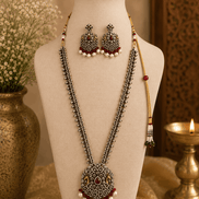 Wine necklace set on bust with layered silver-tone chains, maroon center pendant, tassel earrings