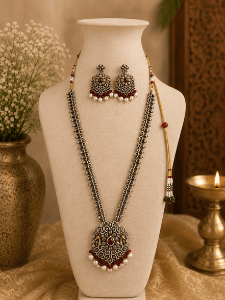 Wine necklace set on bust with layered silver-tone chains, maroon center pendant, tassel earrings