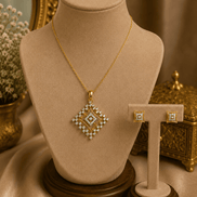 Gold-tone pendant necklace with square crystal pendant and two stud earrings on stand