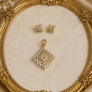 Gold-tone square crystal pendant and matching stud earrings on ornate jewelry display
