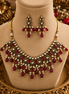 Gold-tone necklace and drop earrings with maroon-red gemstones and pearl accents