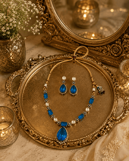 Blue teardrop pendant necklace set with matching drop earrings and pearl bead details