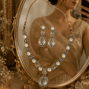 Clear teardrop crystal necklace set with matching drop earrings and oval stone details