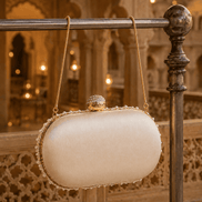 Cream fabric half-moon clutch with gold beaded trim and small top clasp