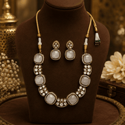 Gold-tone gemstone necklace set with oval white and dark stones, plus matching drop earrings