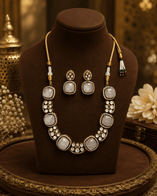 Gold-tone gemstone necklace set with oval white and dark stones, plus matching drop earrings