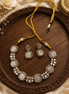 Gold-tone gemstone necklace with round white stones and matching bead drop earrings