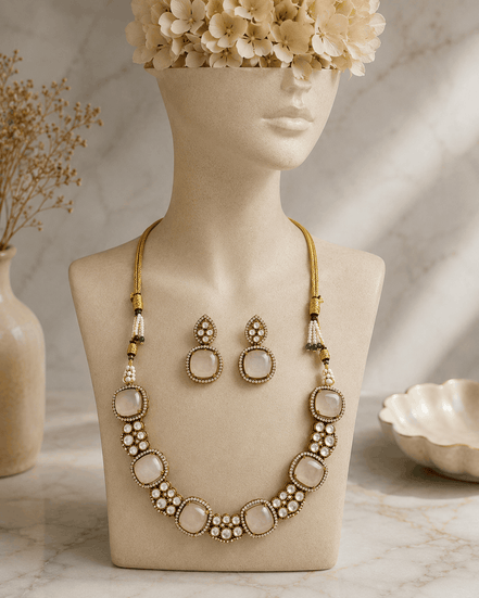 Gold-tone gemstone necklace with oval pendants and bezel stones, plus matching drop earrings