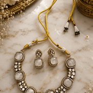Gold-tone gemstone necklace with large oval white stones and round crystal accents