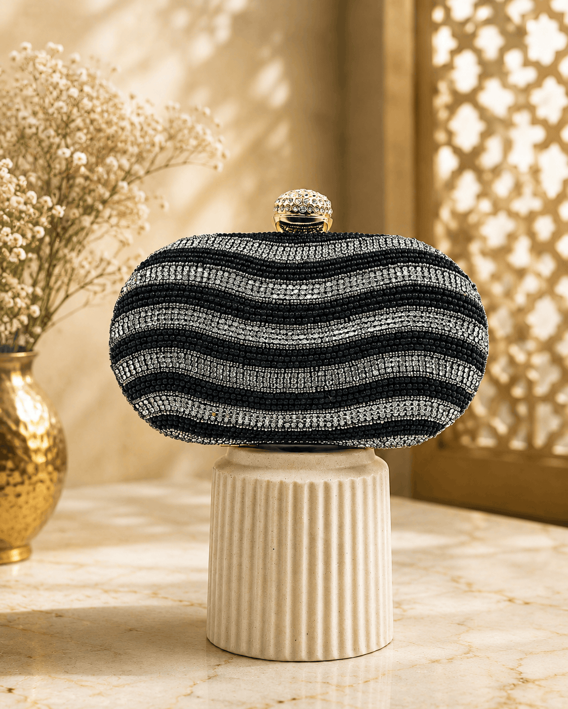 Black and white striped beaded clutch with gold clasp; rounded dome top.