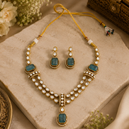 Gold kundan necklace set with peacock-blue teardrop stones, pearl-like beads, and drop earrings