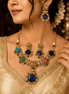 Gold-tone statement necklace with blue and green gemstones and matching drop earrings