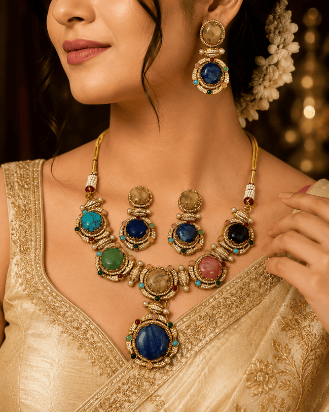 Gold-tone statement necklace with blue and green gemstones and matching drop earrings