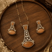 Gold-tone pendant necklace set with orange teardrop earrings and ornate central pendant