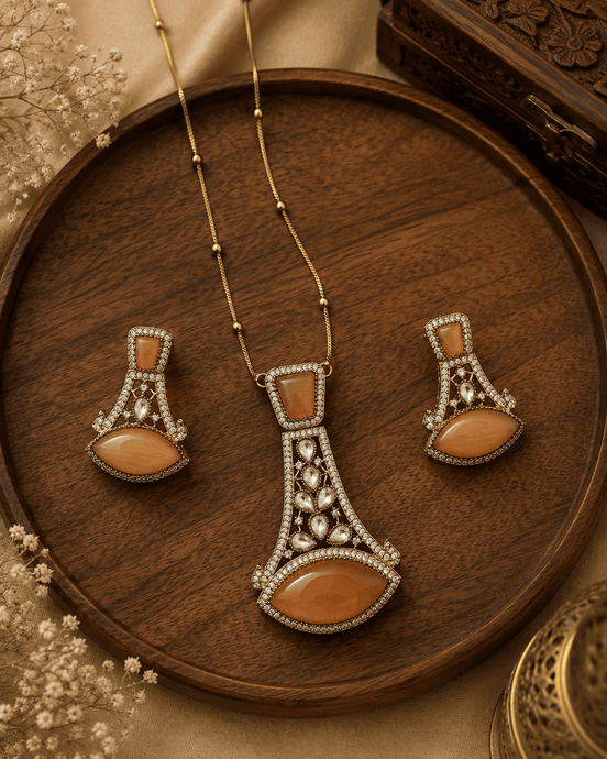 Gold-tone pendant necklace set with orange teardrop earrings and ornate central pendant