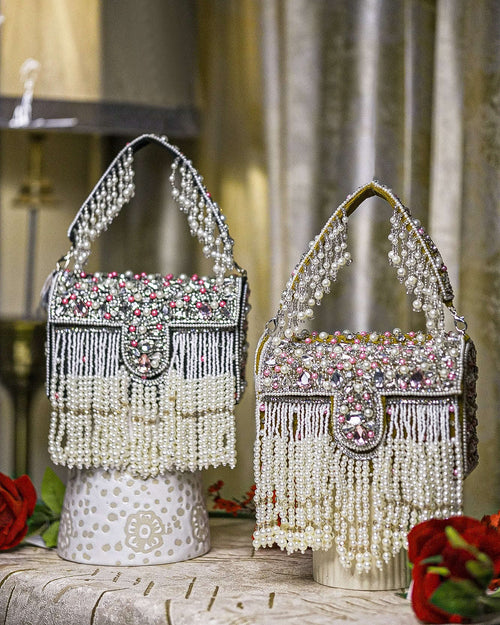 Pearl crystal fringe handbags, one black and one mustard, with jeweled tops and tassels