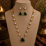 Gold-toned layered necklace with dark green teardrop pendant and multicolor bead accents