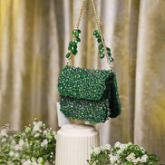 Emerald green crystal mini bag with flap front, dangling charm tassel, and shoulder chains