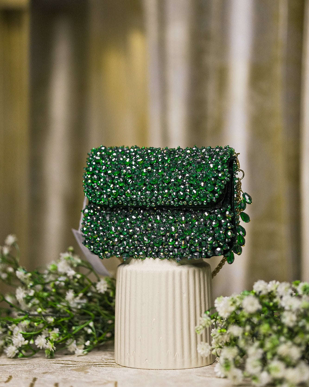 Emerald green crystal mini bag with flap closure and side beaded tassel details