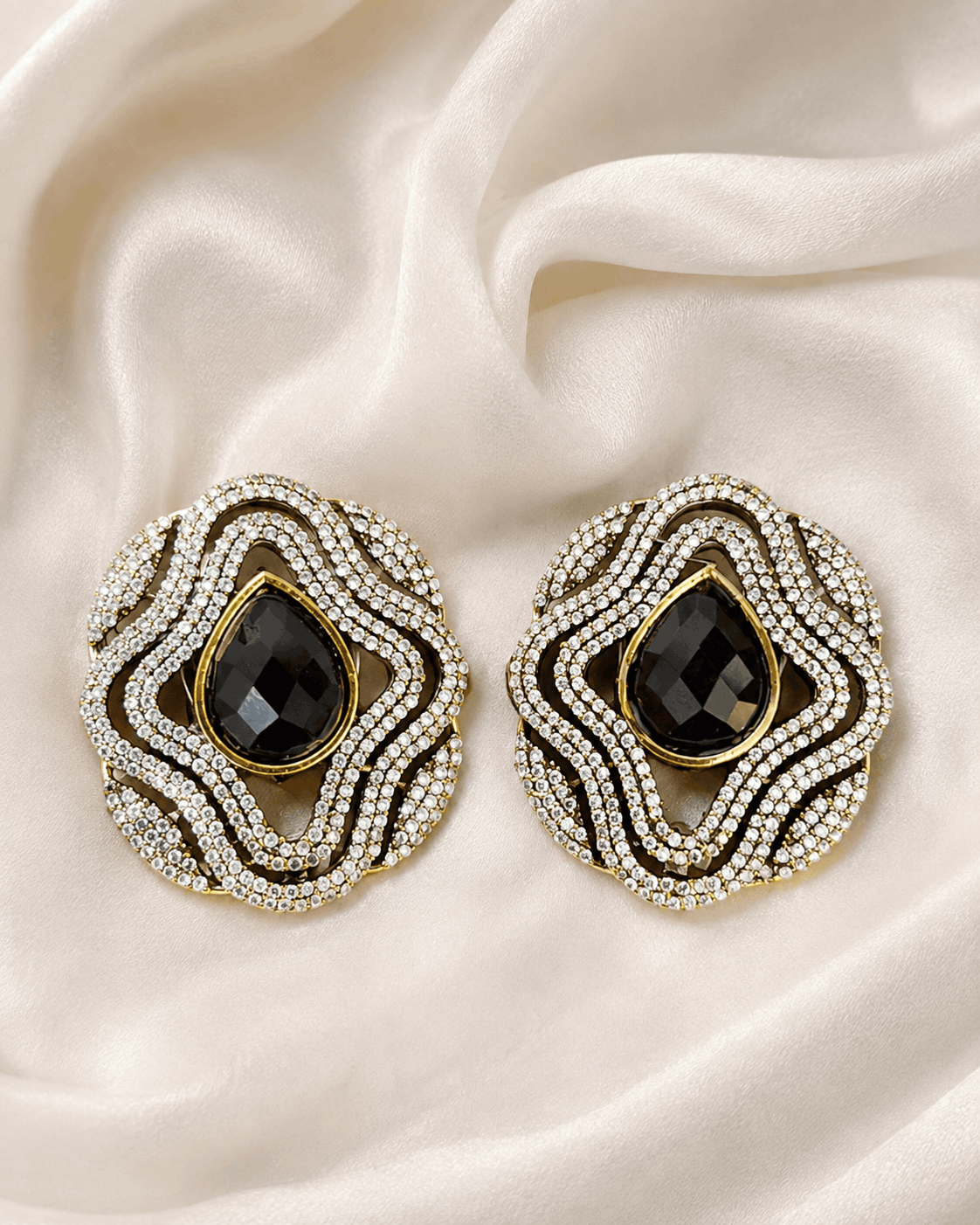 Brass-tone statement stud earrings with black teardrop center and sparkling crystal border