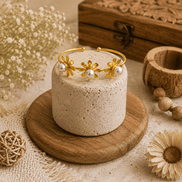 Gold-tone open cuff bracelet with floral charms and pearl beads