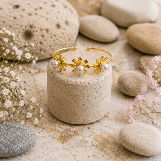Gold-tone open cuff bracelet with three flower charms and pearl accents