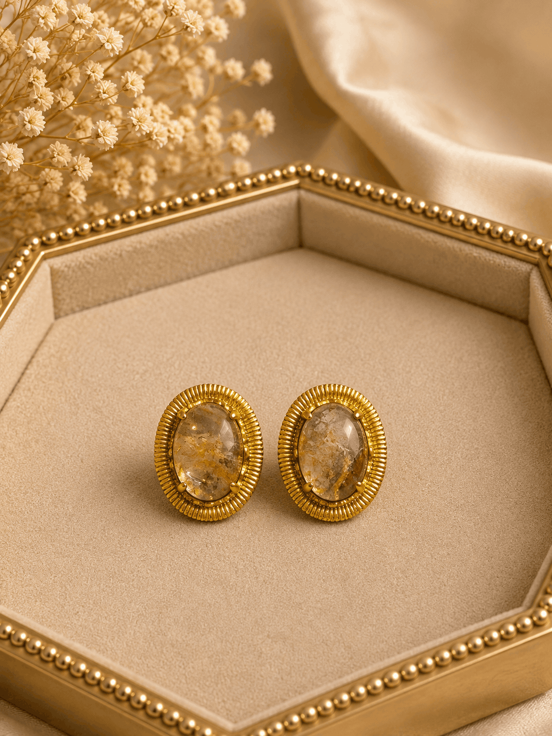 Oval amber/white stone stud earrings with gold-tone ridged bezel