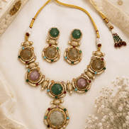 Gold-tone necklace and four matching earrings with green, blue, and pink gemstones