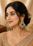 Chandbali earrings with gold-tone kundan, green stones, dangling teardrops.