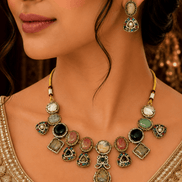 Gold-toned necklace and earrings set with green teardrop and round stone drop details