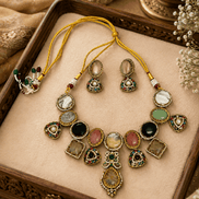 Gold-toned necklace set with green teardrop center pendant and multicolor stone charms