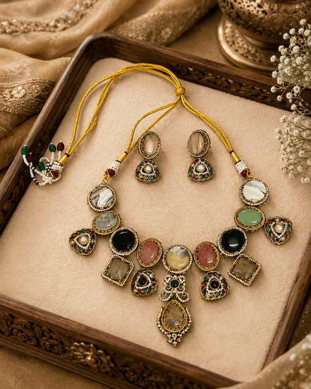 Gold-toned necklace set with green teardrop center pendant and multicolor stone charms