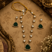 Layered gold-toned necklace with multiple dark green teardrop pendants on bead chain