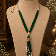 Teal green cord tassel necklace with gold oval centerpiece and dangling pearl strands