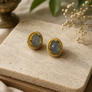 Oval grey stone stud earrings with gold-tone ridged bezel