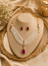 Gold-tone pearl necklace set with maroon pendant and matching stud earrings