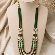 Teal green layered beaded necklace with tassel drops and gold flower stud earrings