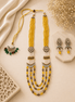 Gold layered beaded necklace set with green-red drops and matching stud earrings